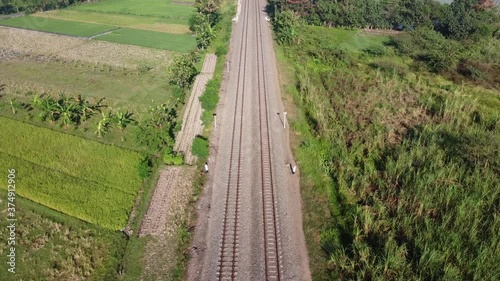 train tracks that cross the rice fields photo