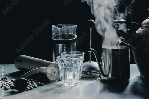 Aromatic coffees in French press coffee maker with couple glass and Antique coffee bean grinder using hand crank,Hot drink is good for health,Wood table,Black background,Natural light,Healthy Eating.