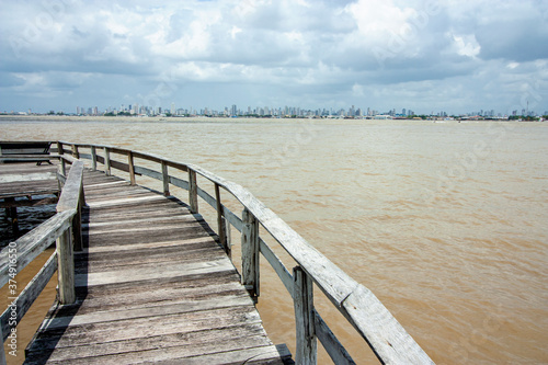 Trapiche de madeira na beira do rio na margem do rio Guajará, com Belém do Pará na linha do horizonte. © Rafael