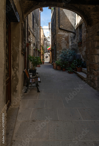 Picturesque alley with bicycle  plants and flowers in the small town of Pienza  Tuscany  Italy
