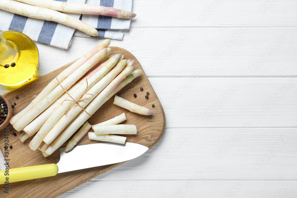 Fresh white asparagus on wooden table, flat lay. Space for text