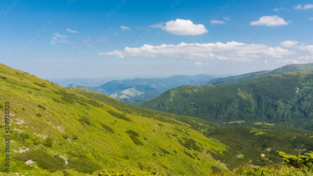 Amazing mountain landscape with blue sky with white clouds, sunny summer day in Carpathians, Ukraine.