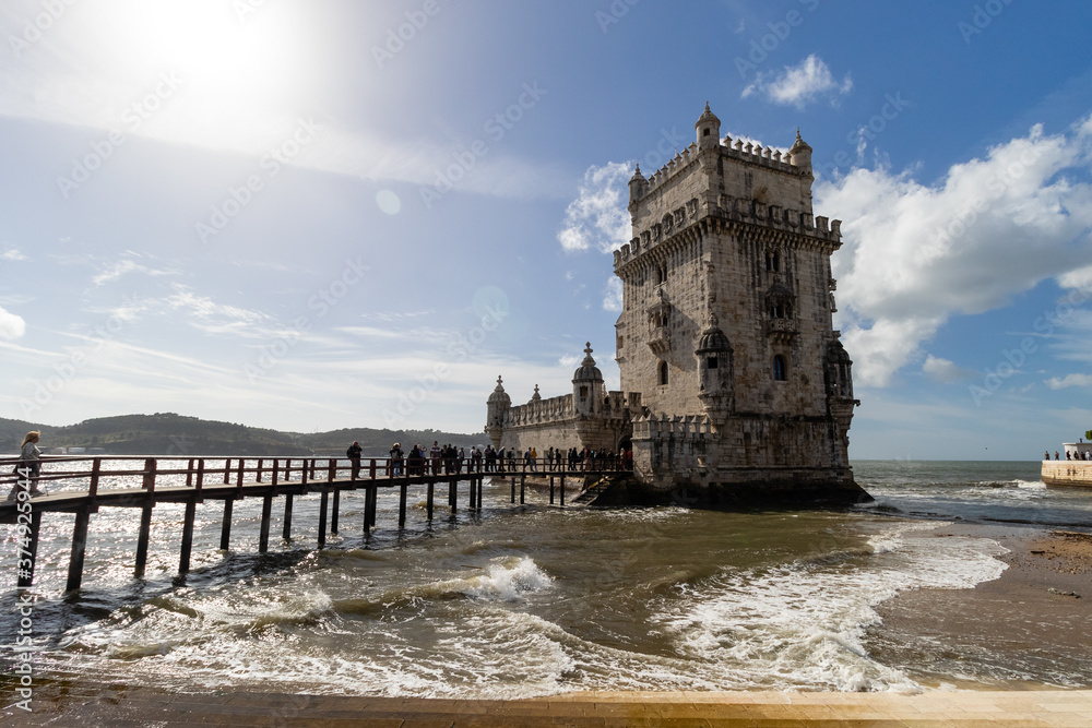 The Tower of Belem surrounded by the ocean and the waves in Lisbon, Portugal