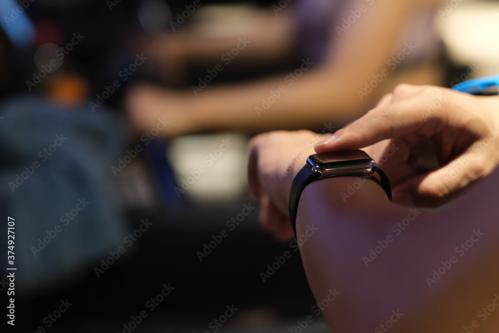 close up hand using smart watch while exercising on treadmill in gym room at night. blur background close up hand using smart watch while exercising on treadmill in gym room at night. blur background