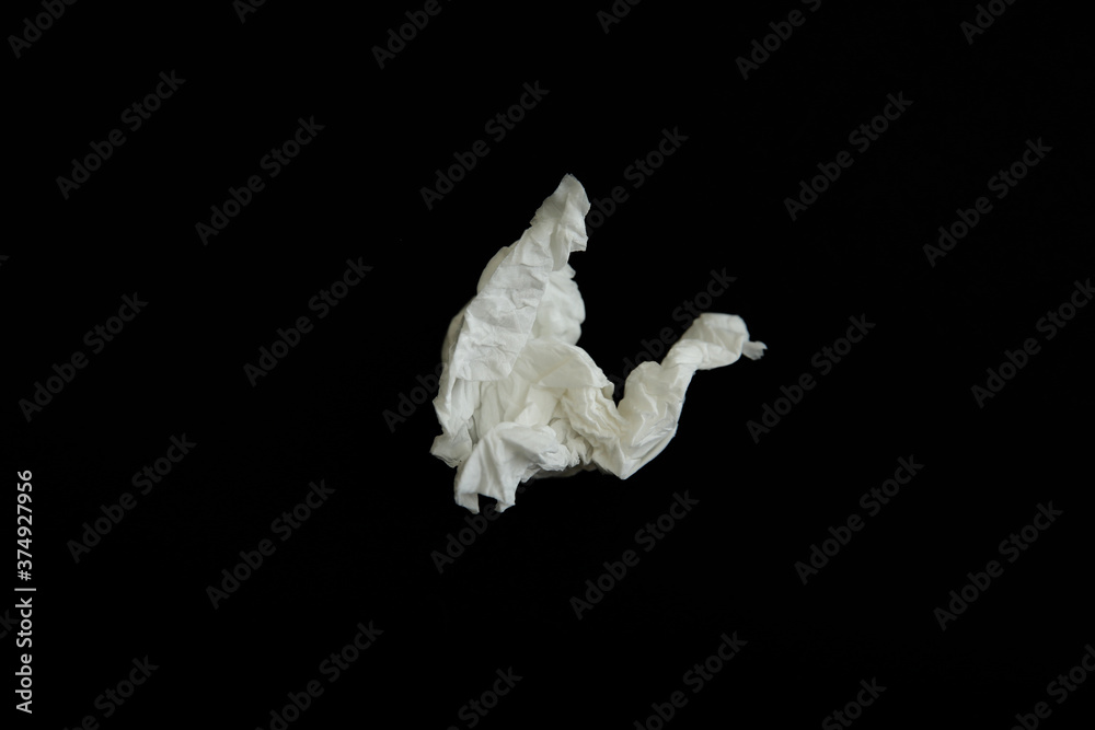 Used paper tissue on black background, top view
