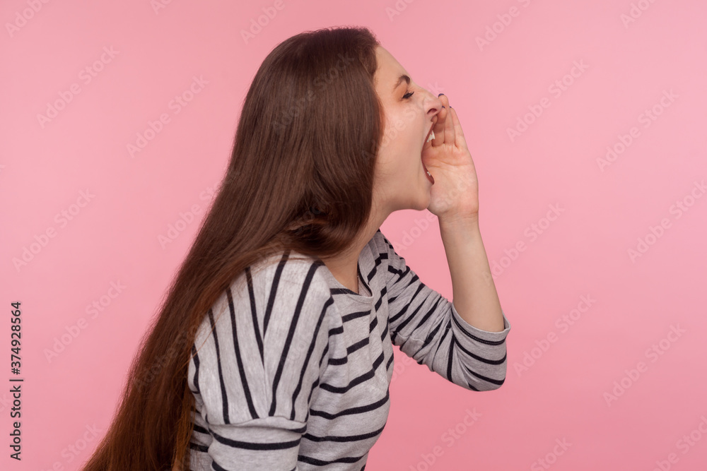 Attention, important announcement! Side view of woman in striped sweatshirt yelling loud, proclaiming bad news, screaming with aggressive angry expression. studio shot isolated on pink background Attention, important announcement! Side view of woman in striped sweatshirt yelling loud, proclaiming bad news, screaming with aggressive angry expression. studio shot isolated on pink background