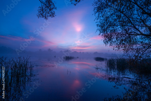 Magic sunrise over the lake. Misty early morning  rural landscape  wilderness  mystical feeling. Serenity lake in magical light