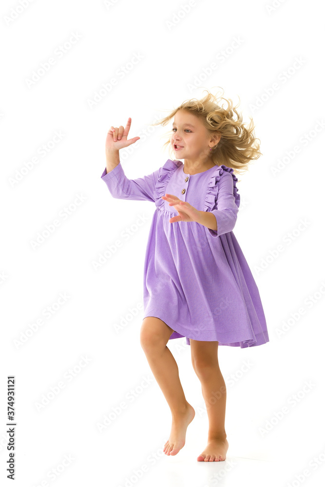 A beautiful little girl stands in the wind, her hair and clothes are developing greatly. The concept of style and fashion. A beautiful little girl stands in the wind, her hair and clothes are developing greatly. The concept of style and fashion.