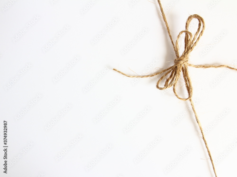 Handmade bow made of natural jute rope at the right corner - decoration for wrapping gifts