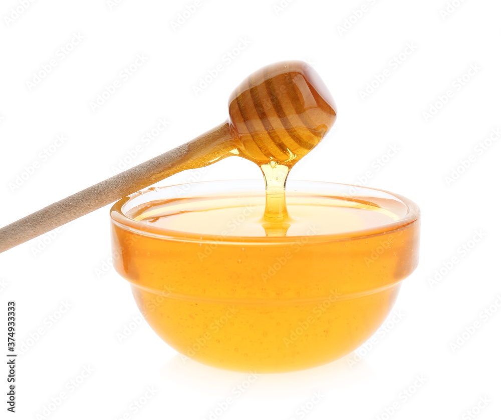 Honey dripping from dipper into bowl on white background Honey dripping from dipper into bowl on white background