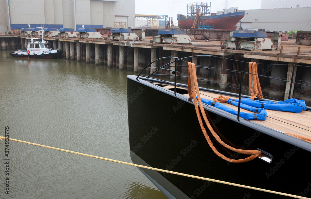 Super sailing yacht in a dock. Ship building industry. Shipyard. Building superyachts. Super sailing yacht in a dock. Ship building industry. Shipyard. Building superyachts.