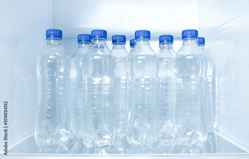 Bottles of pure water on shelf inside refrigerator Bottles of pure water on shelf inside refrigerator