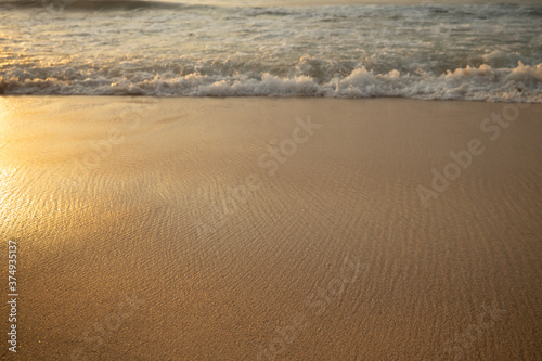 Scenic seascape. Milky foam waves at the beach. Sunset time. Waterscape for background. Selected soft art focus. Sunlight reflection on the water and sand. Balangan beach  Bali  Indonesia