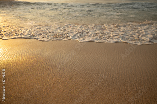 Scenic seascape. Milky foam waves at the beach. Sunset time. Waterscape for background. Selected soft art focus. Sunlight reflection on the water and sand. Balangan beach  Bali  Indonesia