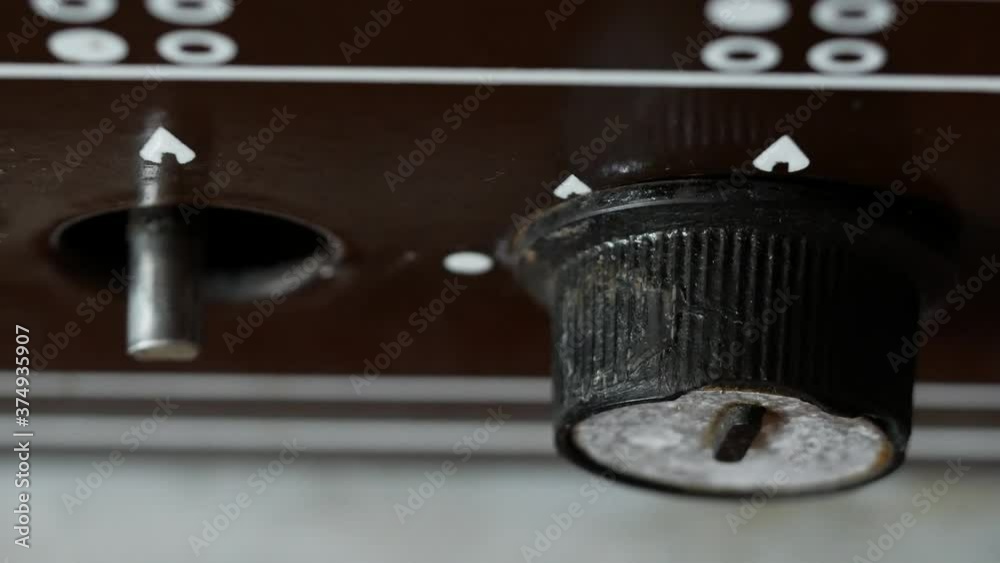 The male hand turns the old gas stove knob to the right and then to the