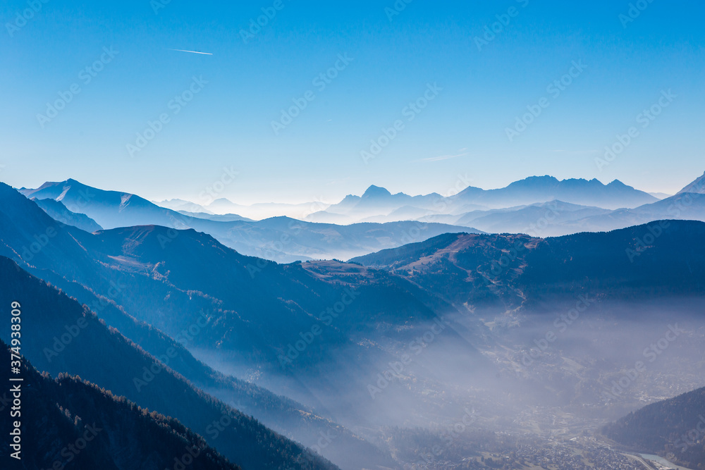 The Chamonix valley in the Alps, France, on a sunny day, with a thin fog covered.