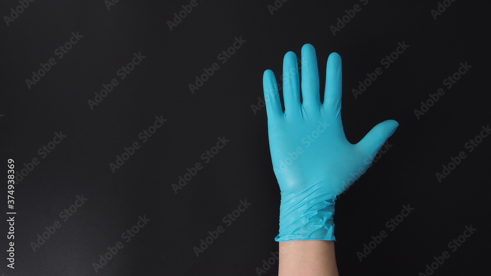Hand wearing blue medical gloves doing five fingers number on black background. Hand wearing blue medical gloves doing five fingers number on black background.