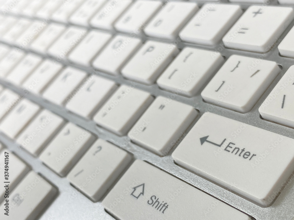 Close up of metallic grey keyboard and white keyboard focus at enter button of a modern technology, internet concept.. Close up of metallic grey keyboard and white keyboard focus at enter button of a modern technology, internet concept..