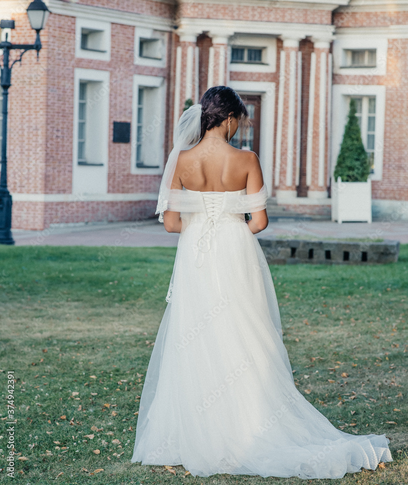 Fototapeta premium young slender bride in a long white elegant wedding dress. honeymoon ceremony