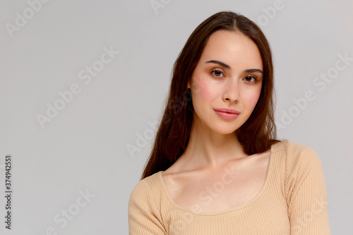 Portrait of a young beautiful cute funny girl smiling looking at the camera on a white background.