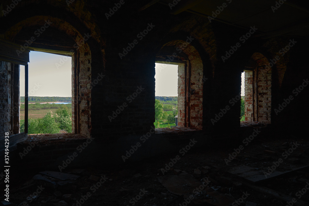 three bright windows in the dark of the old ruined Christian Church