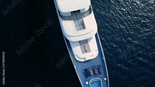 Drone top view on sensual sexy woman lay on deck of beautiful white boat. Private yacht cruise ticket lifestyle enjoying life in open sea. Rich and famous stars and celebrities photo