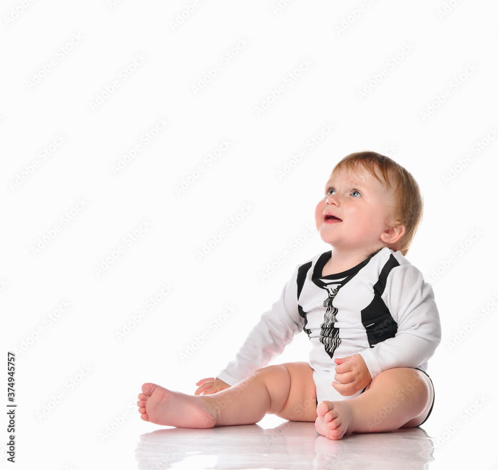Adorable little boy in black and white bodysuit looking on white background. Adorable little boy in black and white bodysuit looking on white background.