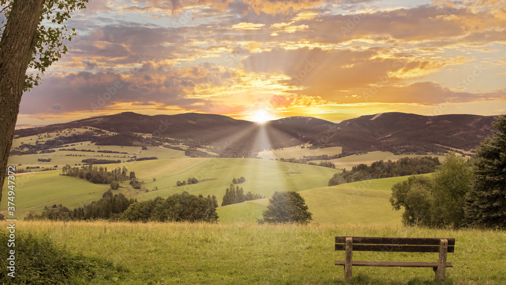 View of bench, valley, mountains, hills and sunset