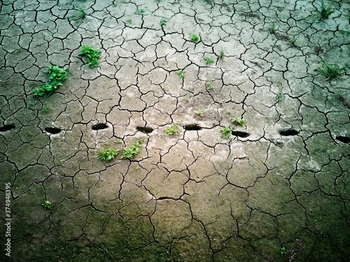 Dried human footprints on cracked grey ground photo