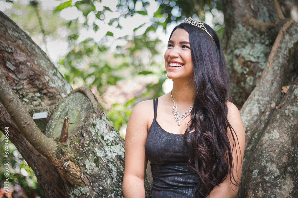 Hermosa mujer joven morena con un vestido de color negro sonriendo en un entorno con mucha naturaleza Hermosa mujer joven morena con un vestido de color negro sonriendo en un entorno con mucha naturaleza