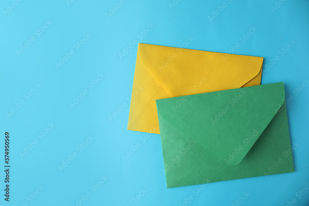 Colorful paper envelopes on light blue background, flat lay. Space for text Colorful paper envelopes on light blue background, flat lay. Space for text