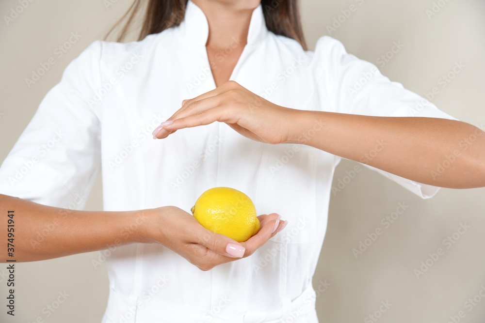 Close up photo of woman's hands in circle with lemon in a white robe. Close up photo of woman's hands in circle with lemon in a white robe.
