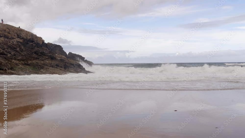 Big Waves Crashing on The Rocky Coast And Sandy Beach Of Cave Island In Donegal, Ireland. - slow push-in shot Big Waves Crashing on The Rocky Coast And Sandy Beach Of Cave Island In Donegal, Ireland. - slow push-in shot