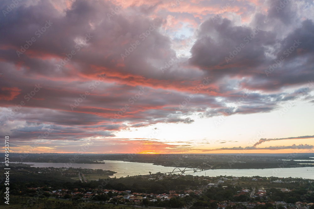 Colorful clouds above Brasilia`s Juscelino Kubitschek bridge and lake Paranoa at sunset.