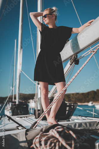 Beautiful girl on sailing ship yacht. Young woman walking on luxury boat. 