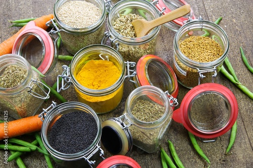 Top view on isolated preserving jars with variety of colorful condiments on wood table - plastic free biodgredable sustainable packaging concept © Ralf