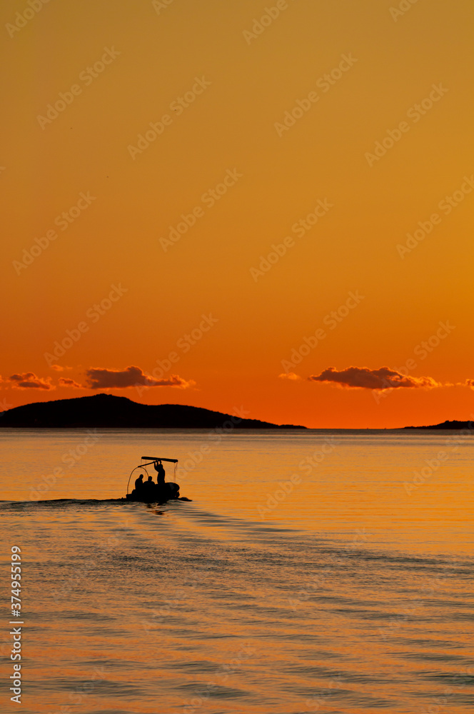 Fishermen on sea at red sunset in Croatia