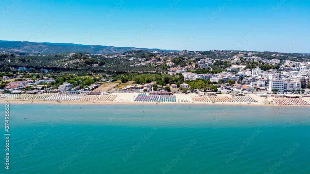 Aerial view of the Spiaggia di Castello, south of Vieste on the Gargano Peninsula in Italy - Alignements of umbrellas in summer for holiday goers in the Adriatic Sea