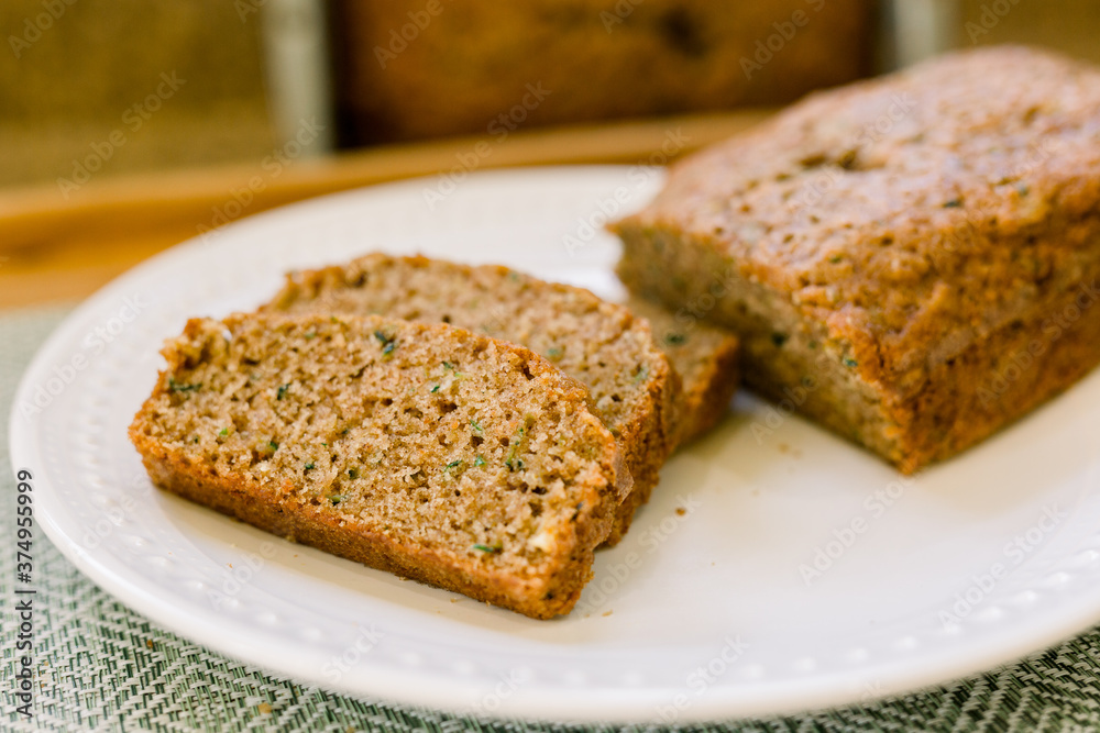 Delicious Slices of Homemade Zucchini Bread on a White Plate in a Kitchen. 