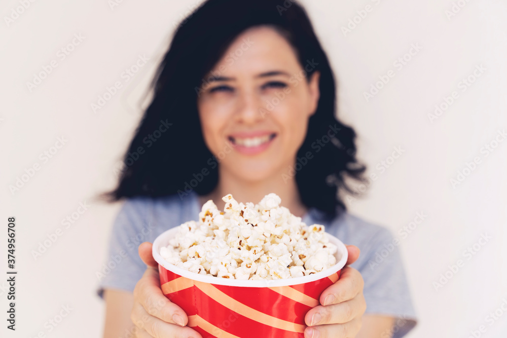 Closeup on bucket with popcorn in hand of young woman Closeup on bucket with popcorn in hand of young woman