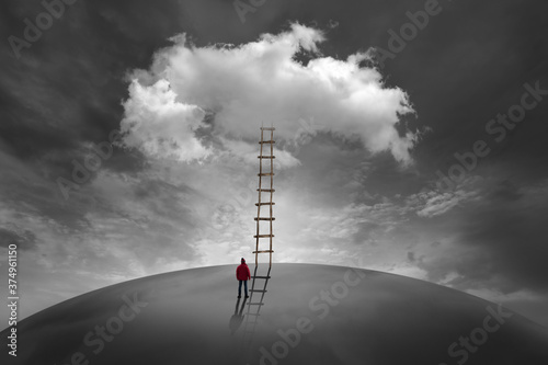 Man in front of a cloud with a wooden ladder photo