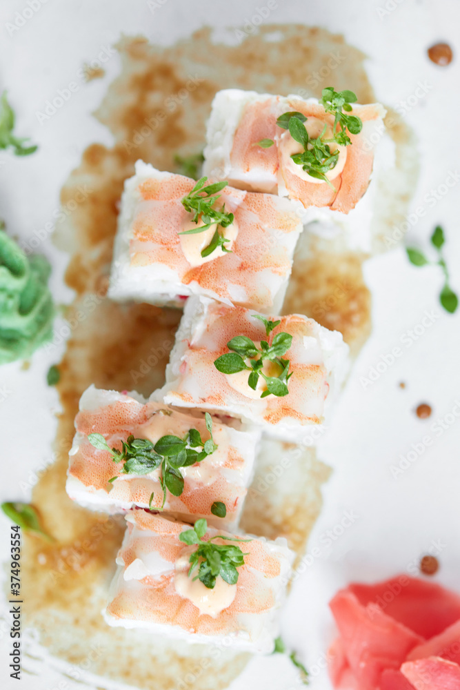 Japanese cuisine, fresh sushi on a light background. Assorted sushi with wasabi, soy sauce and ginger Japanese cuisine, fresh sushi on a light background. Assorted sushi with wasabi, soy sauce and ginger