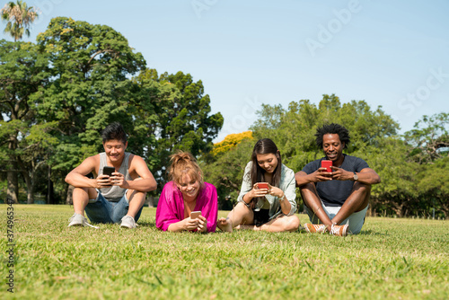 Friends using their phone in the park