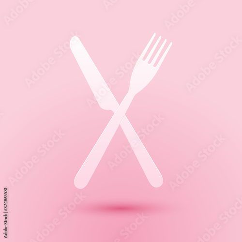 Paper cut Crossed fork and knife icon isolated on pink background. Restaurant icon. Paper art style. Vector.