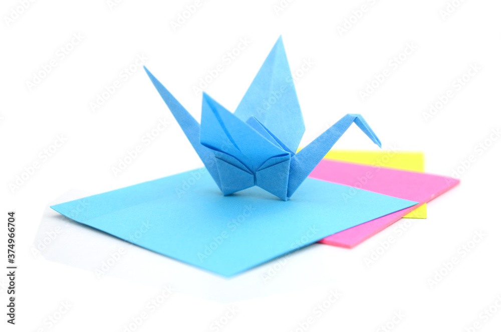 A blue origami crane with paper sheets