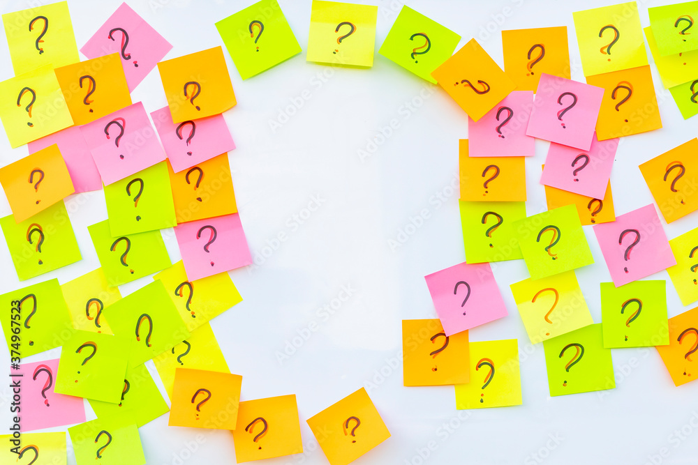 Obraz premium Daylight. natural wood is neatly glued together and paper of different colors is tilted to the top painted in white. There are several of them. Texture. a question mark is drawn on the stickers.