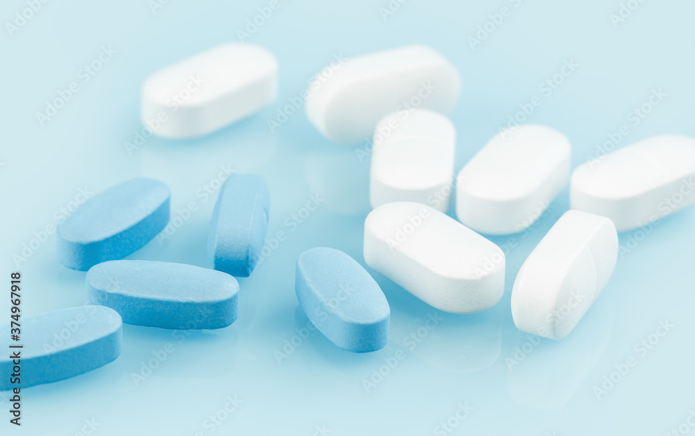 Medical background of many white and blue capsule tablets or pills on the  table. Close up. Healthcare pharmacy and medicine concept. Painkillers or prescription  drugs consumption Stock Photo | Adobe Stock