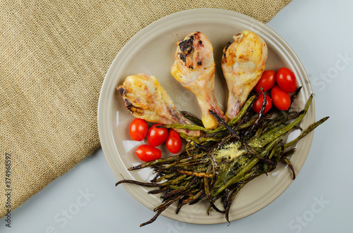 Top view dish roasted drumstick, tometo, asparagus on the napkin photo