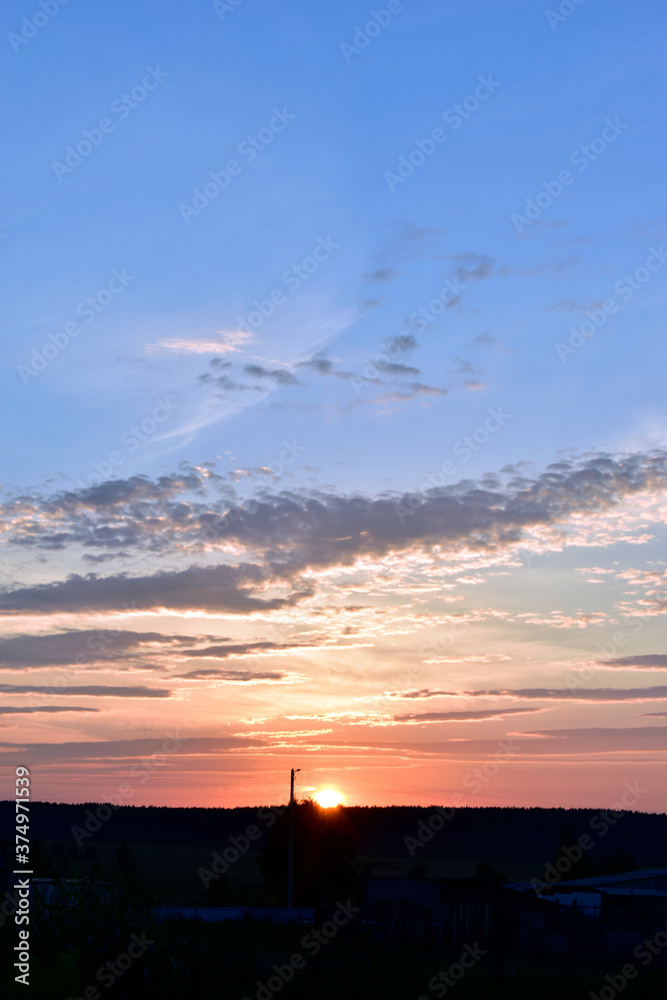 Fototapeta premium Evening sunset landscape orange clouds and a trace of the plane