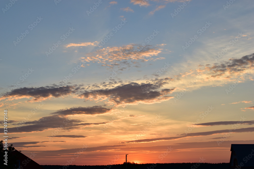 Naklejka premium Evening sunset landscape orange clouds and a trace of the plane